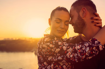 romantic couple kissing outdoor at the sunset