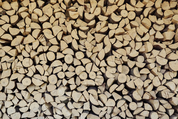 wall firewood. background of dry chopped firewood logs in a pile