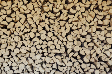 wall firewood. background of dry chopped firewood logs in a pile