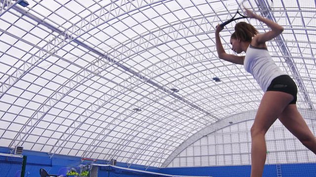 Low angle shot of tennis player receiving rally of shots and returning them with forehand and backhand strokes