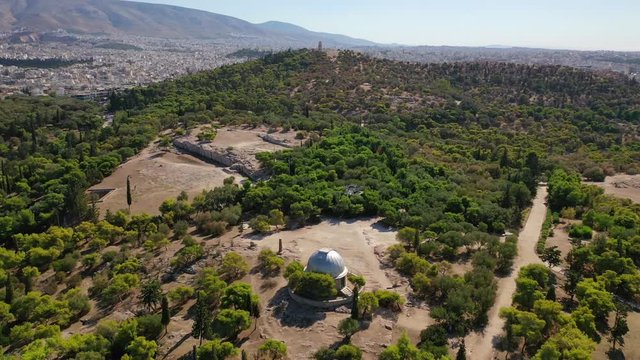 Aerial drone video of Ancient Pnyka a famous gothering place of Athenians with great views to Acropolis hill and the Parthenon, Athens historic centre, Attica, Greece