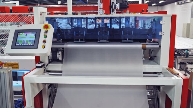 Closeup of special machinery at solar production panels factory. Industrial technic at plant. Modern green energy production.