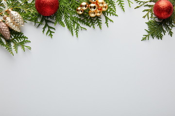 top view of shiny golden and red Christmas decoration on green thuja branches isolated on white