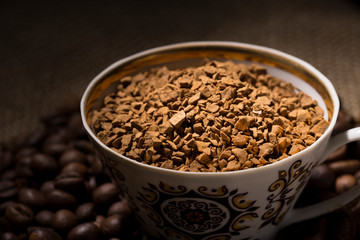 The instant coffee and coffee beans on burlap or sackcloth background 
