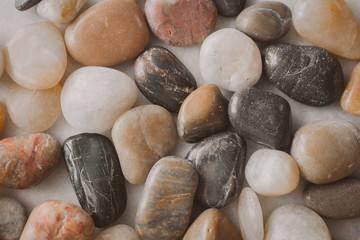 Stones and pebbles as background. Multicolor pebbles at the seaside close up view. 