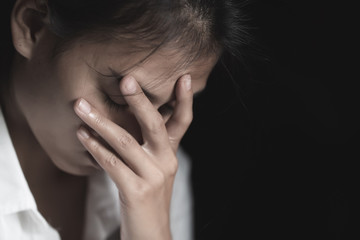 Fototapeta premium A young woman crying and covering her face. depression or domestic violence. The concept of sexual harassment against women and rape. human trafficking, international women's day.