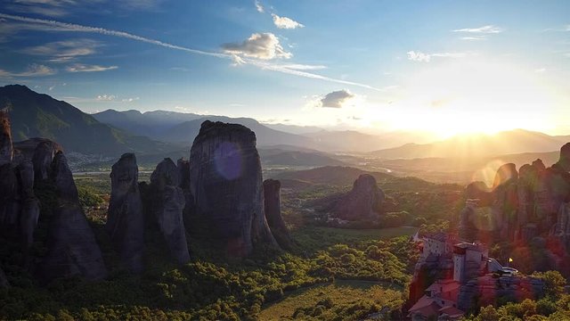 Astonishing view of Meteora valley at sunset, rays running across rocks and over Rousanou nunnery and St Nicholas Anapausas monastery, Kastraki, Kalampaka, Thessaly, Greece