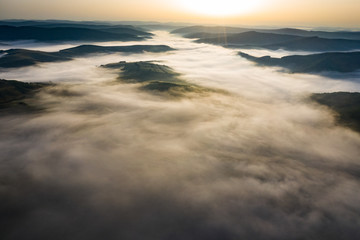 Misty sunrise with sunrays over the hills in Transylvania, Romania.