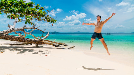 Happy summer lifestyle young Asian man traveler jump on sunny vacation beach, Active healthy tourist male joy travel Phuket Trang Thailand holidays fun beach, Tourism beautiful destinations place Asia