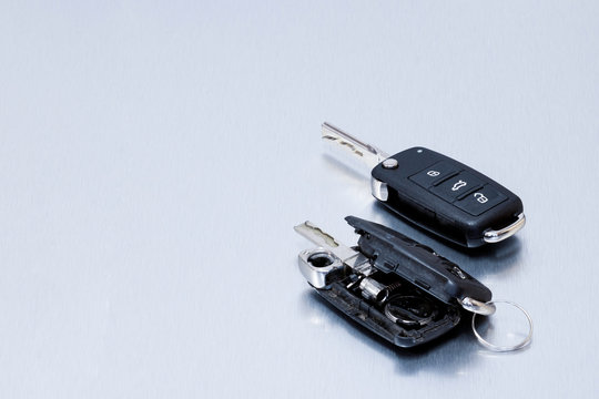 Broken or damaged car key fob and new remote vehicle key on aluminium background. Repair of broken or damaged remote key fob of any vehicle car service.- Image