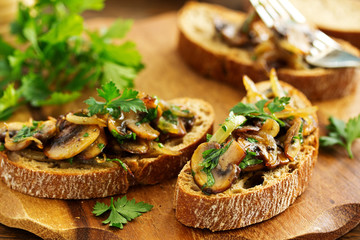 Bruschetta with fried mushrooms with onions and parsley.