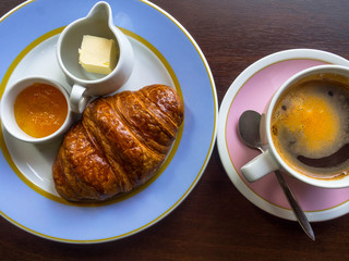 Continental breakfast with fresh croissants, apple jam, butter, coffee with smile shape