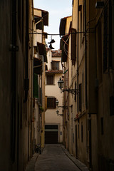 Florence narrow street with a pair of shoes hanging  on a wire. shoe tossing.