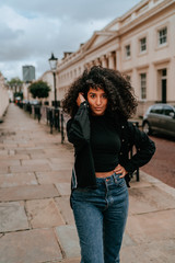 Fototapeta premium Portrait Charming Young African Woman with Curly Hair, Street Style