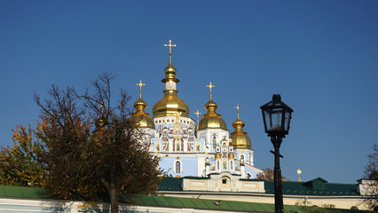 Fototapeta na wymiar Domes of St. Michael's Golden-Domed Cathedral in Kiev against a blue sky