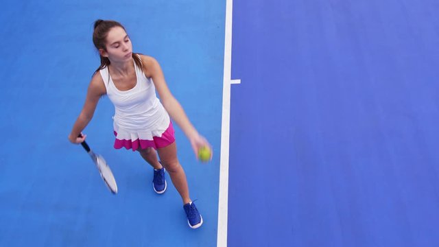 High angle shot of young tennis player throwing ball Into the air to do topspin serve and to start the game