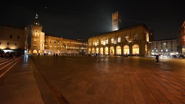 Bologna, Italy - October 2019 - Unknown people walk in the evening among the buildings and monuments of the historic city center, followed by the shadows of the night