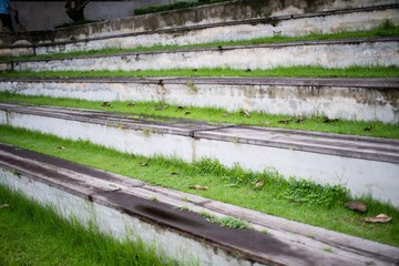 Fototapeta na wymiar Old Concrete and wood Grandstand with grass in the garden open stadium