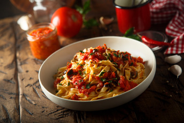 Homemade pasta with tomato sauce and olives