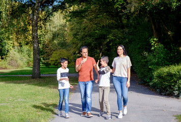 walking family with two children in park