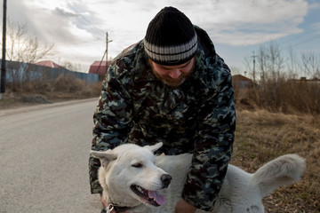 A man in overalls for a walk with a dog