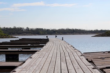 Fototapeta premium A view of the long empty pier at the lake.