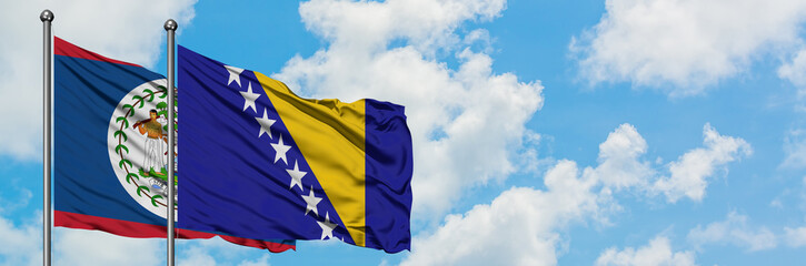 Belize and Bosnia Herzegovina flag waving in the wind against white cloudy blue sky together. Diplomacy concept, international relations.
