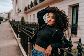 Naklejka premium Portrait Charming Young African Woman with Curly Hair, Street Style