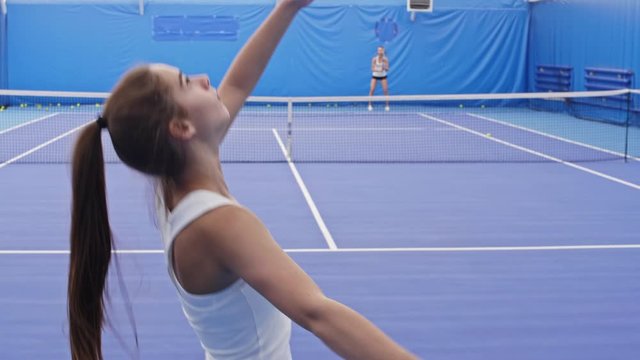Tilt up shot of young tennis athlete serving ball and winning with ace