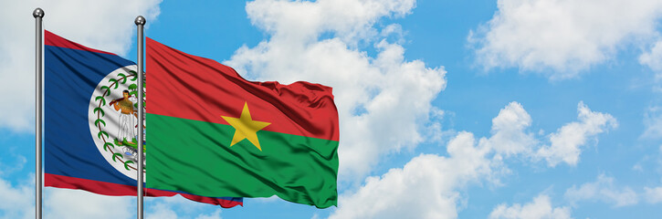 Obraz premium Belize and Burkina Faso flag waving in the wind against white cloudy blue sky together. Diplomacy concept, international relations.