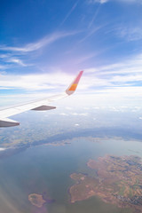 Aircraft Wing on blue sky and white clouds background.