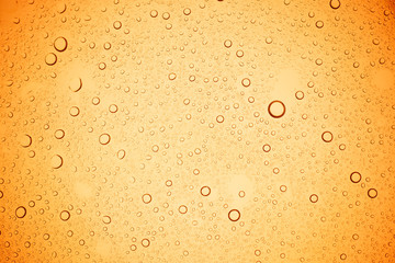 Rain droplets on yellow glass background, Water drops on yellow glass.