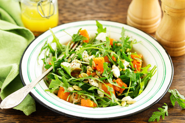 salad with pumpkin, feta and arugula. . Selective focus