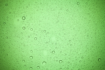 Rain droplets on green glass background, Water drops on green glass.