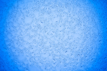 Rain droplets on blue glass background, Water drops on blue glass.