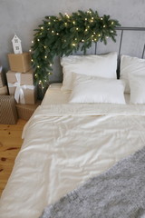 bed with spruce branches in the room decorated for Christmas