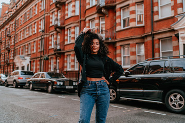 Fototapeta premium Portrait Charming Young African Woman with Curly Hair, Street Style