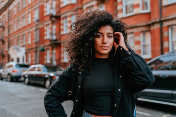 Fototapeta premium Portrait Charming Young African Woman with Curly Hair, Street Style