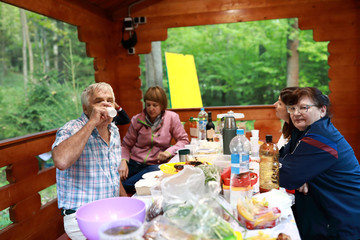 Family has lunch in wooden arbor