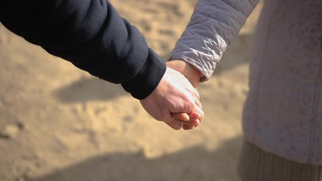 man and woman holding hands in park