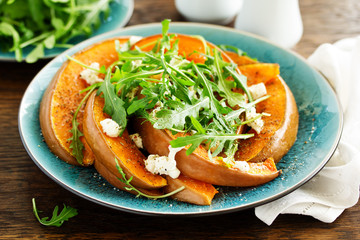 Baked pumpkin with feta and herbs. Selective focus
