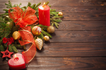 red and golden Christmas decoration with burning candle on wooden background