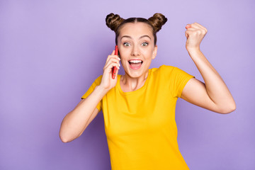 Obraz na płótnie Canvas Great news. Photo of pretty lady holding telephone speaking with partners excited with working achievement wear yellow t-shirt isolated on pastel purple background