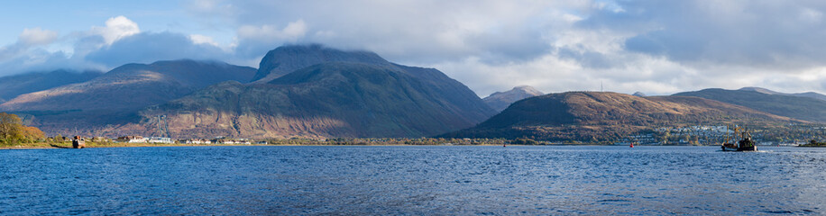 a view of ben nevis near fort william shot in winter as wintry storms approach the summit showing calm waters and cloudy stormy skies as seen from corpach beach