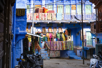Stunning view of colorful clothes, bags and patchwork hanging outside a small shop on the streets of the blue city of Jodhpur during the Diwali (Deepvali or Dipvali) festival. Rajasthan, India.
