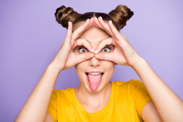 Close up photo of funky youngster lady holding hands near eyes making specs sticking tongue out...