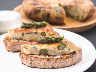 Vegetable omelette with asparagus on a sourdough bread slice. Asparagus tortilla on toast.  