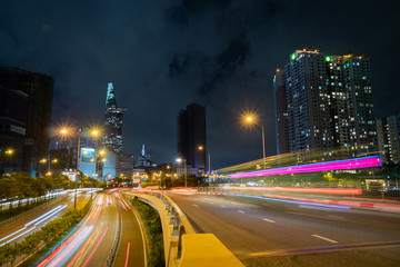 Fototapeta na wymiar Saigon Cityscape Nighttime. Urban Metropolis with illuminated road and Bitexco Financial Tower at Background. Saigon aka ho chi minh city, Vietnam.futuristic light trail on highway