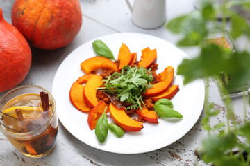 Baked pumpkin appetizing salad with arugula, autumn appetizer