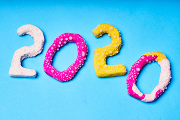 2020 New year design concept. Colored figures from plasticine on a blue background